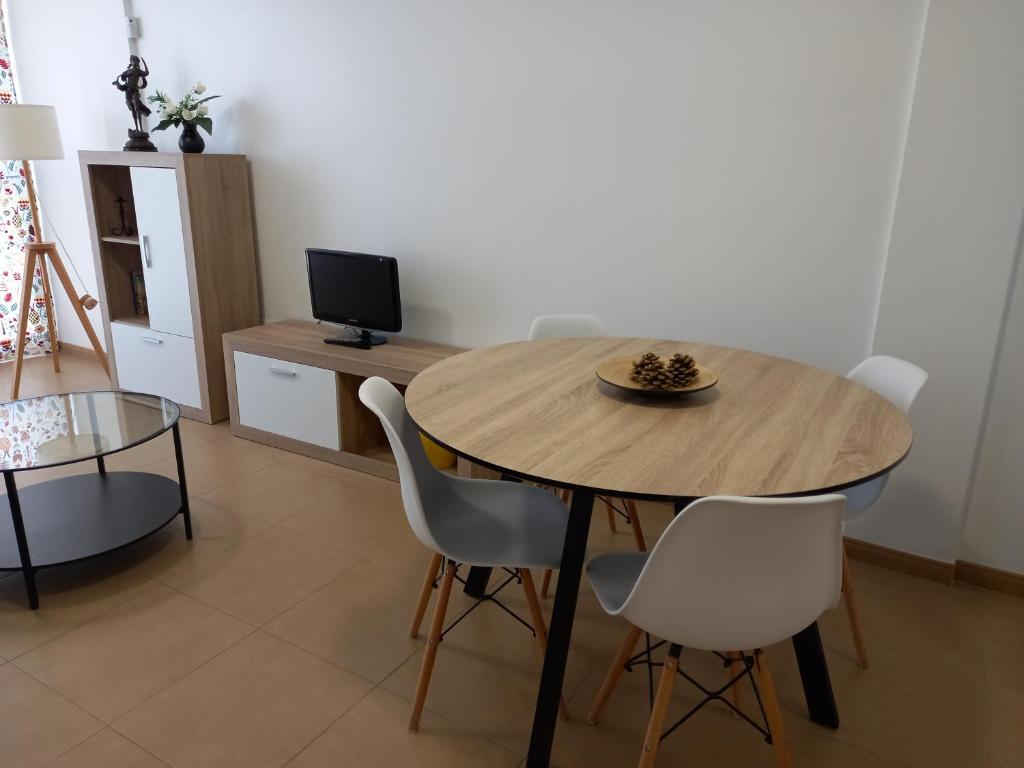 a dining room with a wooden table and chairs at Apartamento El Ingenio in Adra