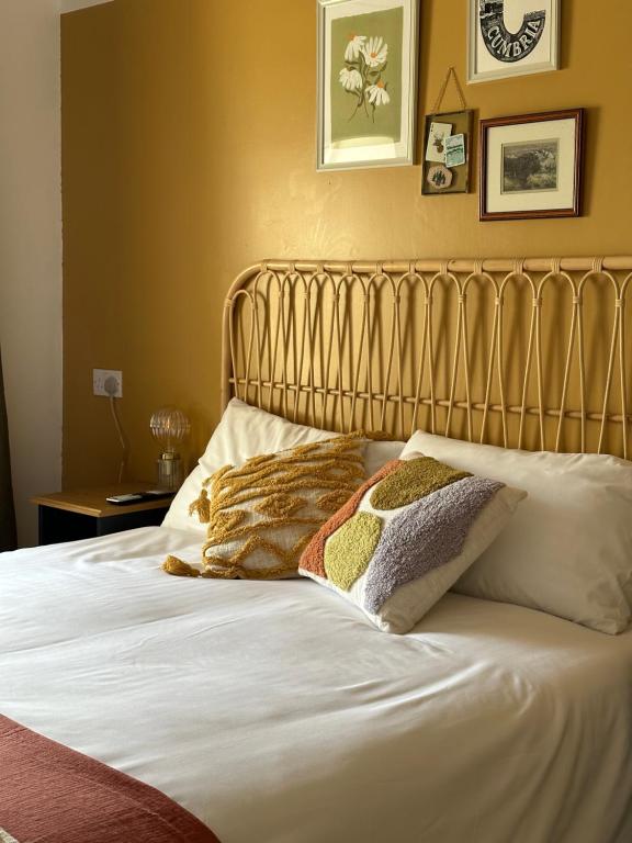 Una cama con tres almohadas encima. en The Highland Drove, en Great Salkeld