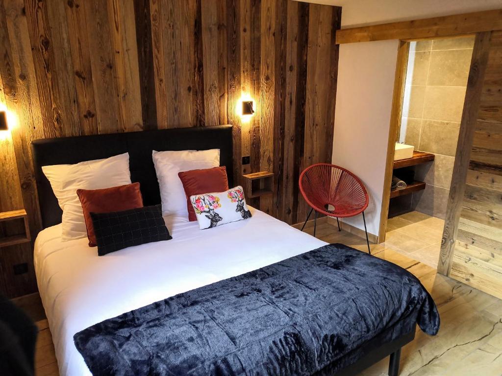 um quarto com uma cama grande e paredes de madeira em Chez Lucienne em Samoëns
