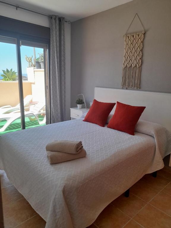 1 dormitorio con 1 cama grande con almohadas rojas en Apartamento Serena beach, en Águilas