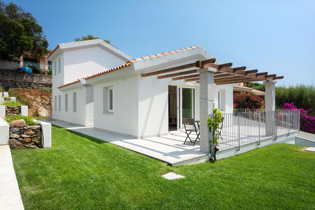 a white house with a patio and green grass at Sardegna è - New Rooms in Olbia