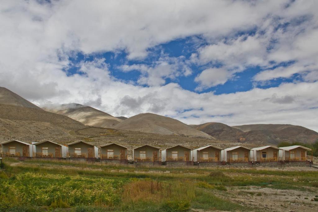 una fila de casas frente a las montañas en Pangong Retreat Camp, en Spangmik