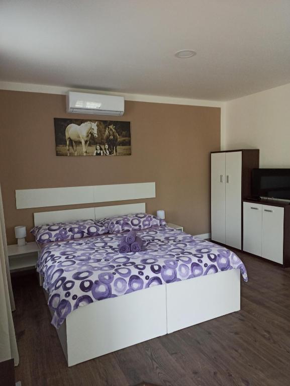 1 dormitorio con 1 cama con edredón morado en Za Humnama, en Hlohovec