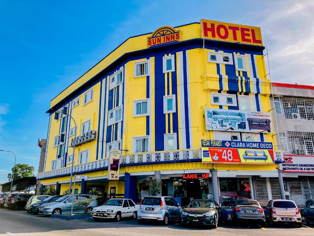 un hotel amarillo con coches estacionados frente a él en Sun Inns Hotel Bandar Puchong Utama, en Puchong