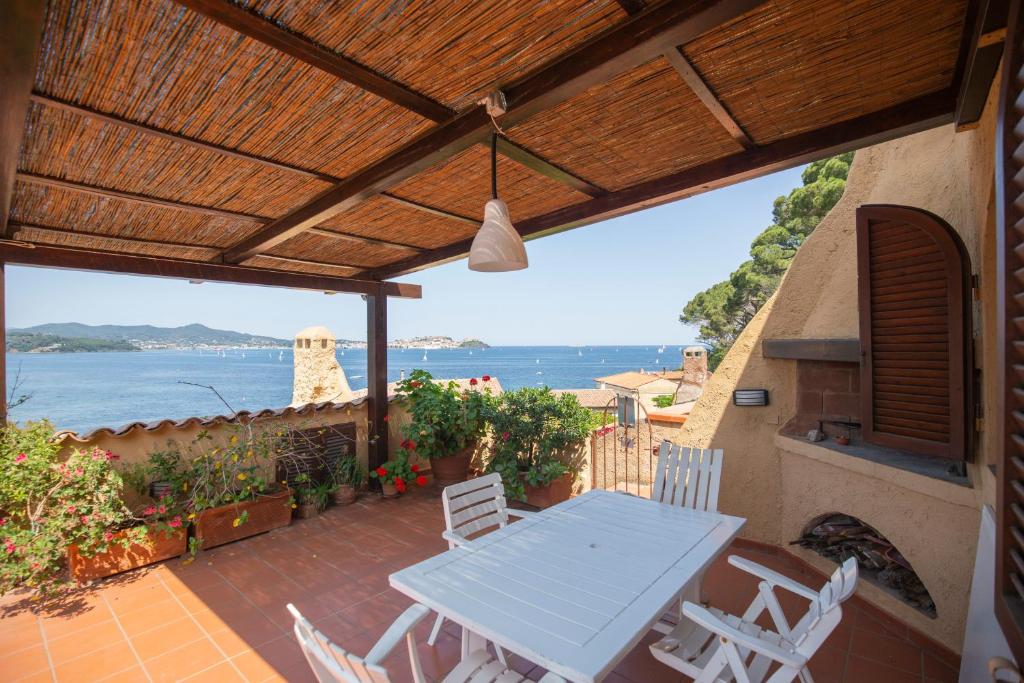 a table and chairs on a patio with a view of the ocean at HelloElba Appartamento Le Tortore in Portoferraio