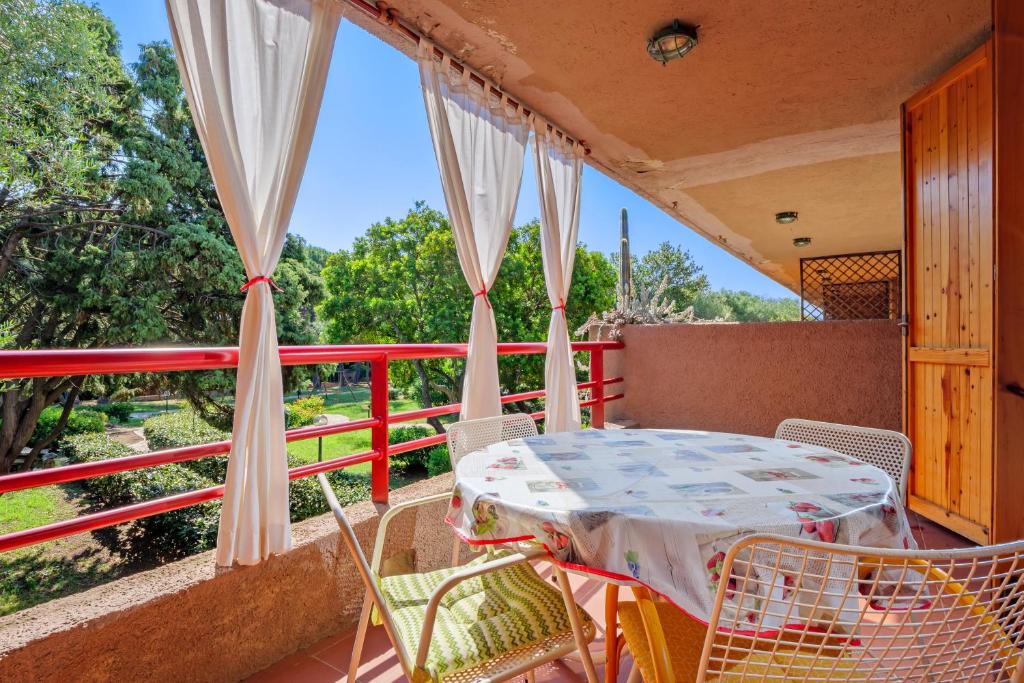 a table and chairs on the balcony of a house at Casa Vacanza Libeccio 2417 in Cugnana