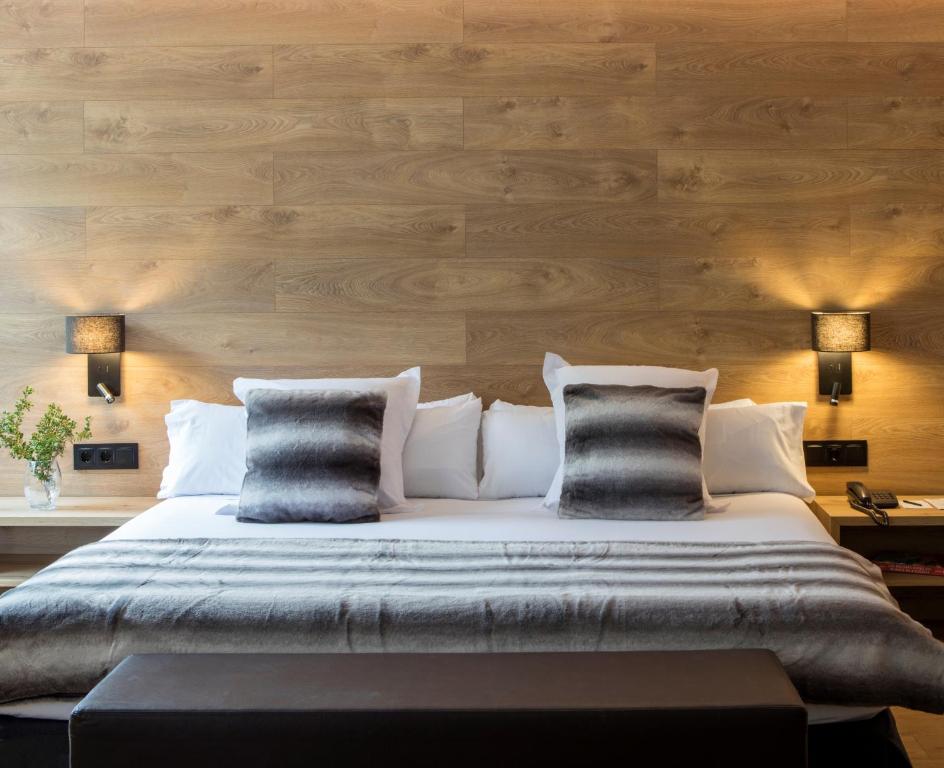 um quarto com uma cama grande e paredes de madeira em Acta Arthotel em Andorra-a-Velha