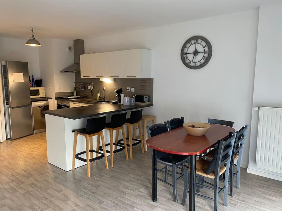 une cuisine avec une table et une horloge au mur dans l'établissement Appt T3 cuisine aménagée et équipée accès PMR, à Saint-Malo