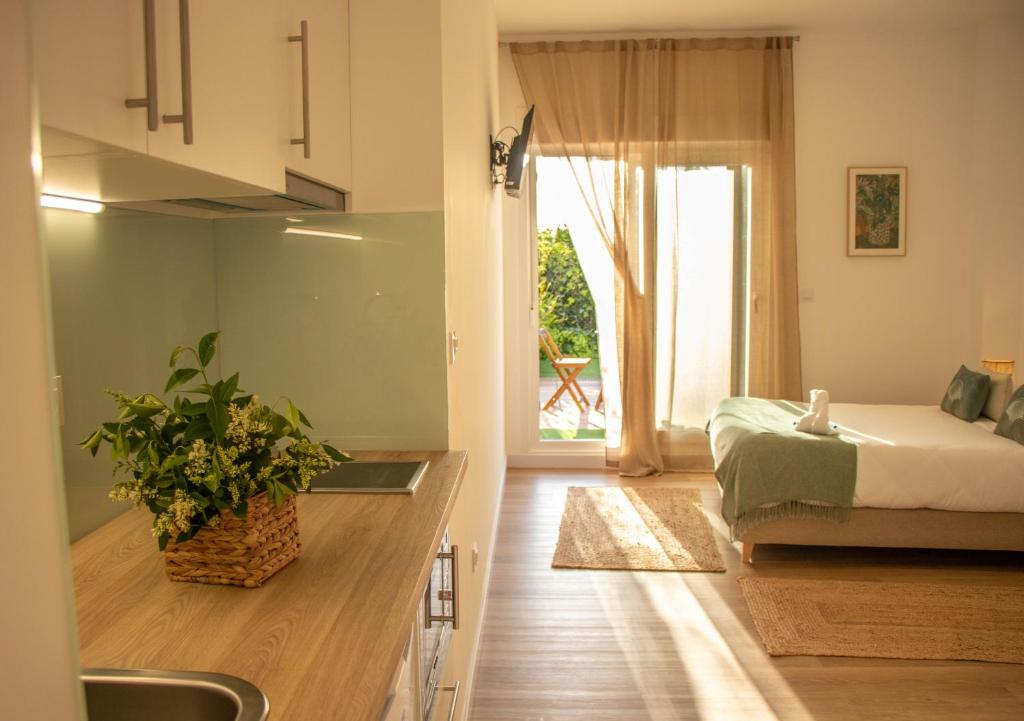 Habitación con cama y cocina con ventana en CostaSerenaSuites en Nigrán