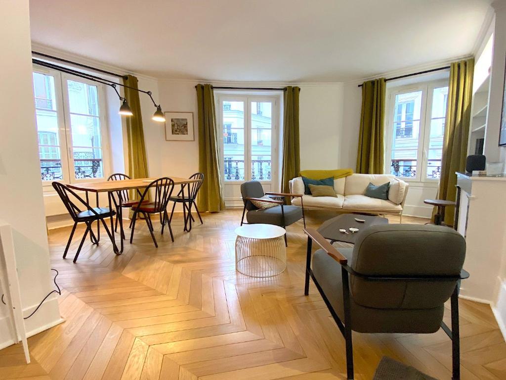 un salon avec un canapé et une table dans l'établissement L'appartement Letac, à Paris