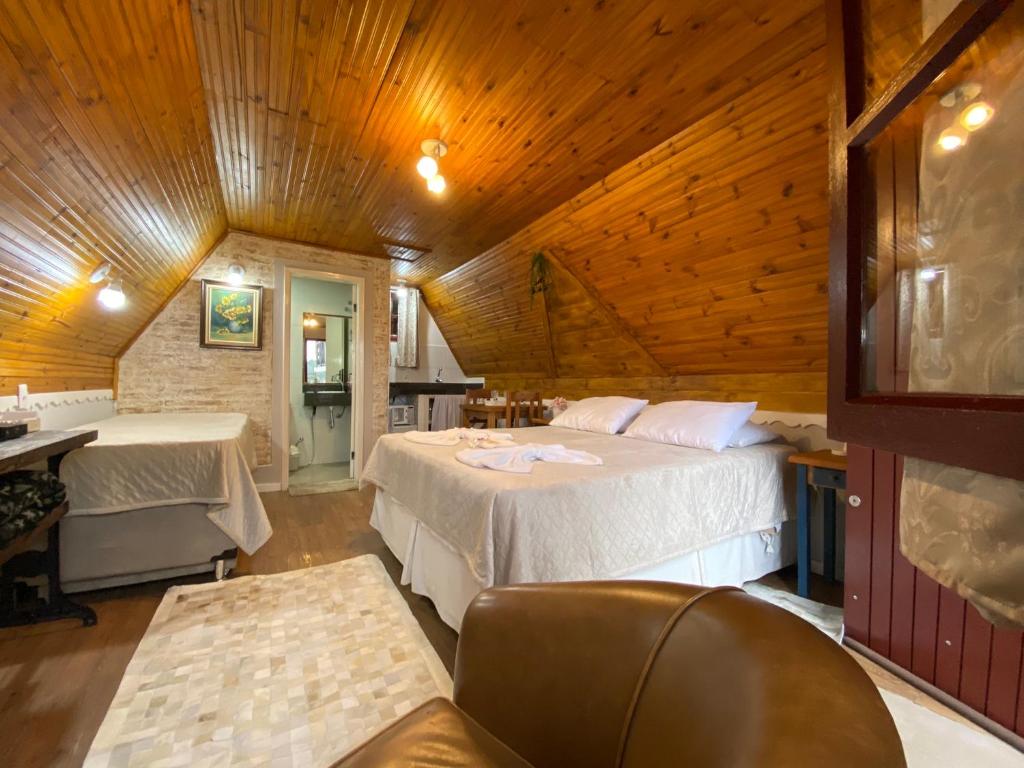 a bedroom with two beds in a room with wooden ceilings at Chalés Paraíso Monte Verde in Monte Verde