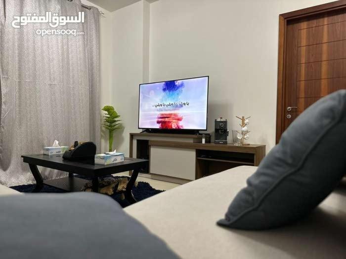 ein Wohnzimmer mit einem Bett und einem TV in der Unterkunft One Bed Room Apartment Muscat Hills in Muscat