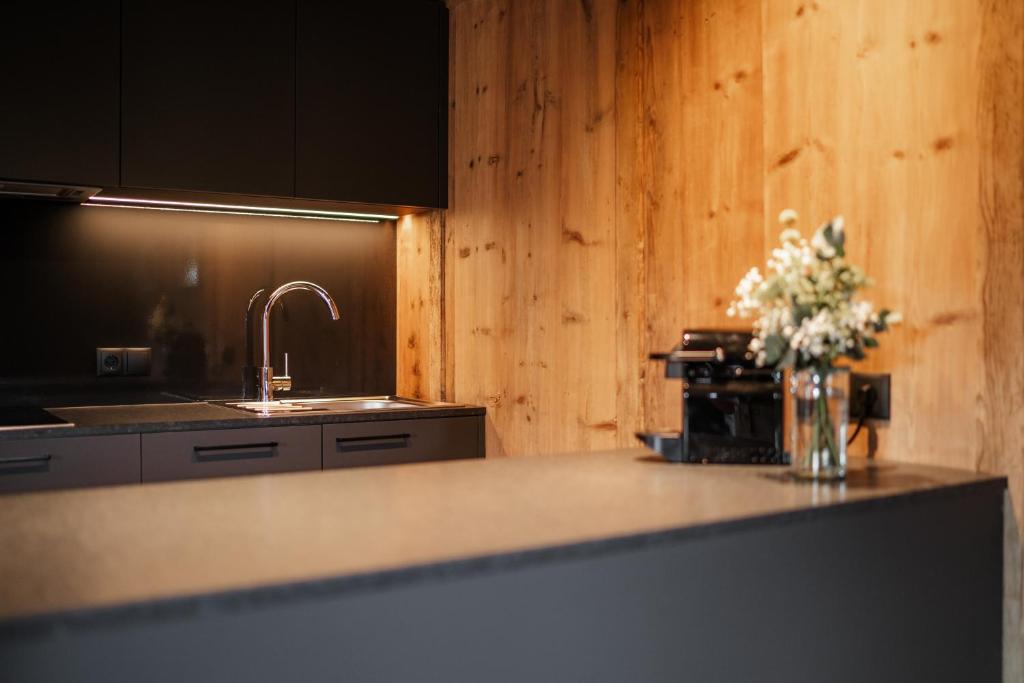 a kitchen with a counter with a vase of flowers on it at Adlhof Apartments in Brunico
