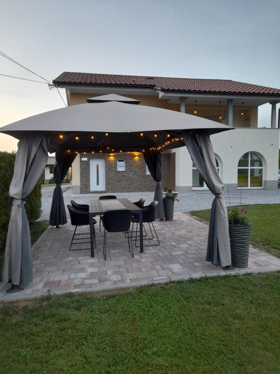 eine Terrasse mit einem Tisch und einem großen Sonnenschirm in der Unterkunft Apartma Relax in Prestranek