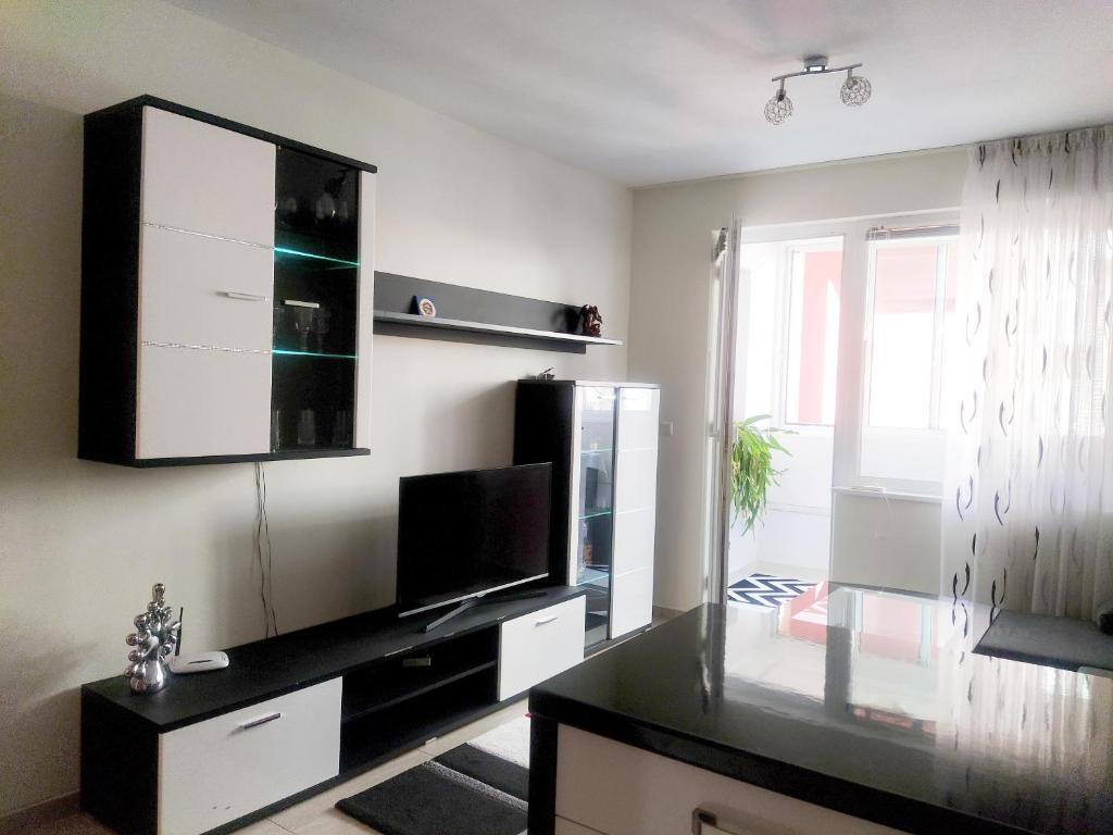 un soggiorno con TV e ripiano nero di Modern apartment in Burgas a Burgas