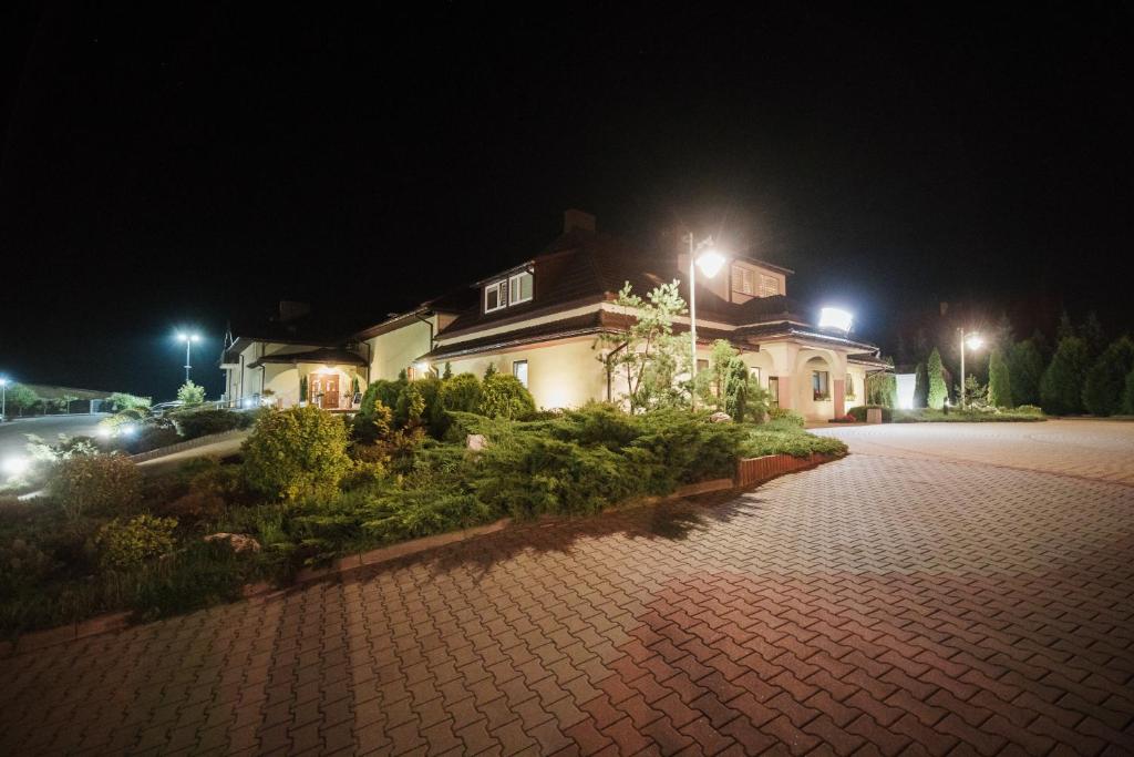 dom na ceglanej drodze w nocy w obiekcie Hotel Hetman w mieście Kroczyce