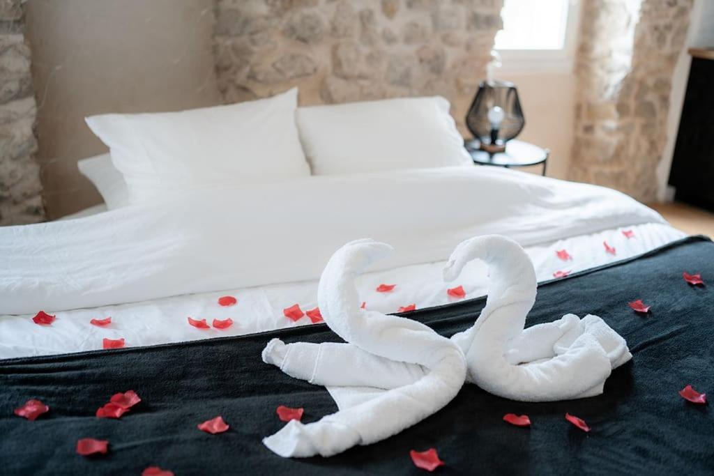 twee handdoek zwanen zittend op een bed met harten bij Ode au bonheur in La Cadière-dʼAzur