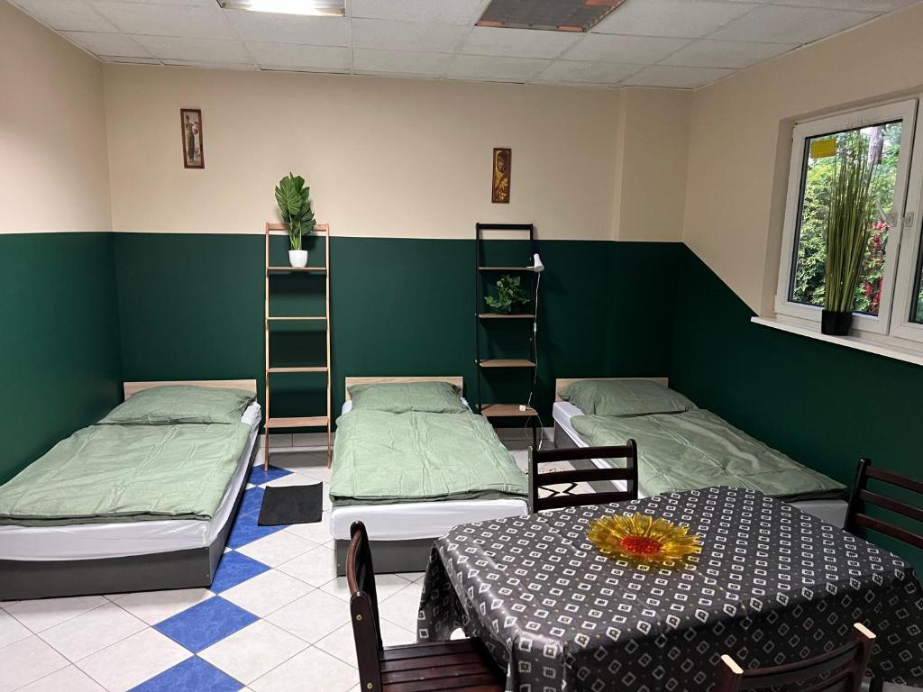 a room with two beds and a table and chairs at U Marty in Jaworzno