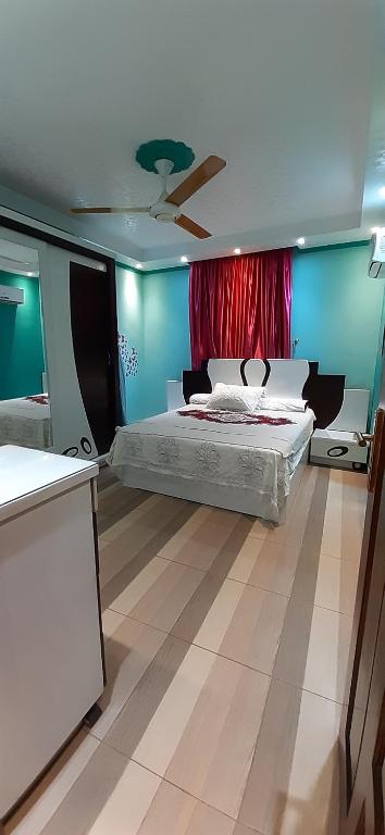 - une chambre avec un lit et un rideau rouge dans l'établissement شقة للايجار بفيصل, au Caire