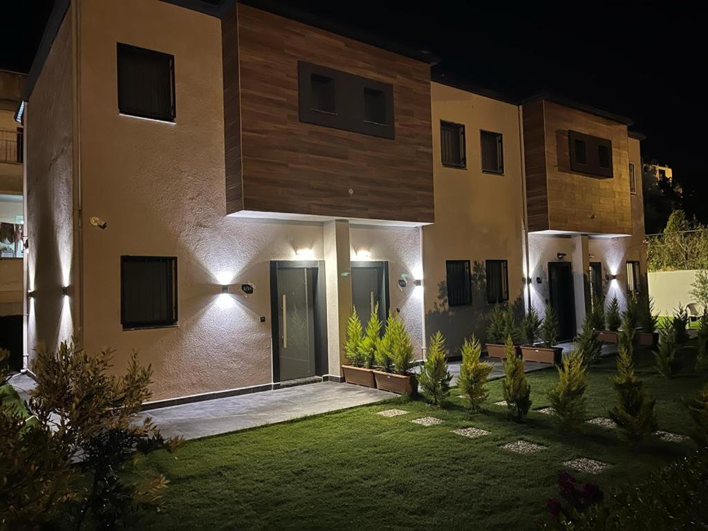 a large house with a courtyard at night at KARAASLAN GROUP TATİL EVLERİ in Kusadası