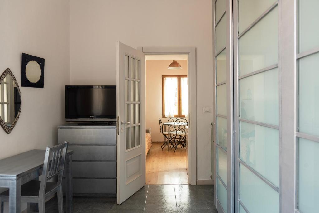 a living room with a table and a television and a door at Casa liberty style in Milan