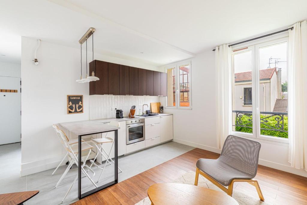 een keuken met een tafel en stoelen in een kamer bij GuestReady - A minimalist comfort in Vanves in Vanves