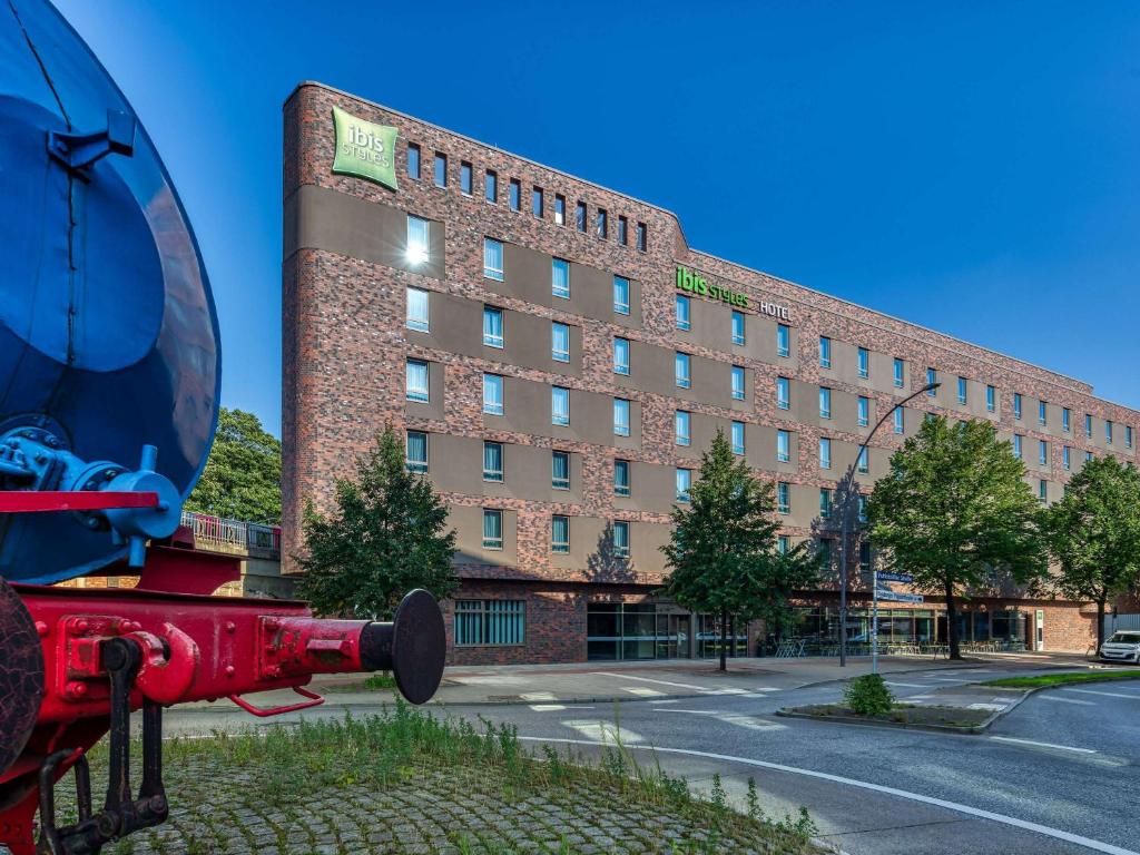 einem roten Hydranten vor einem Gebäude in der Unterkunft ibis Styles Hamburg Barmbek in Hamburg