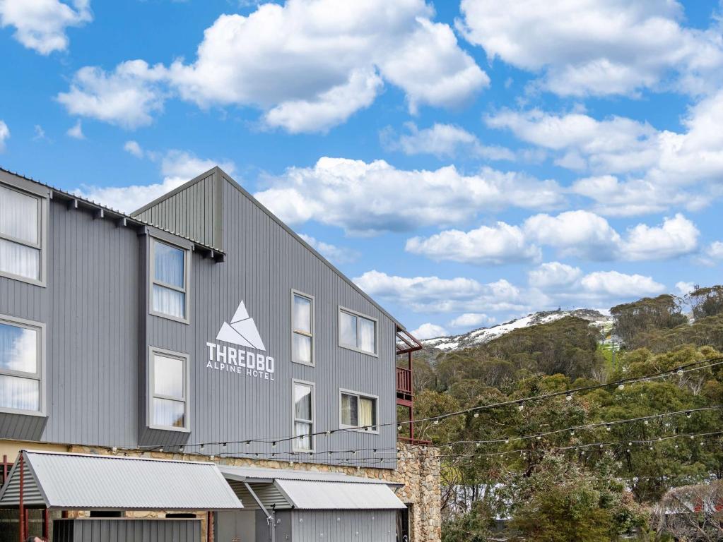 a building with a mountain in the background at Thredbo Alpine Hotel in Thredbo