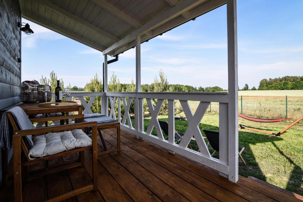a screened porch with a hammock and a view of a field at Pogodny domek in Kołczewo