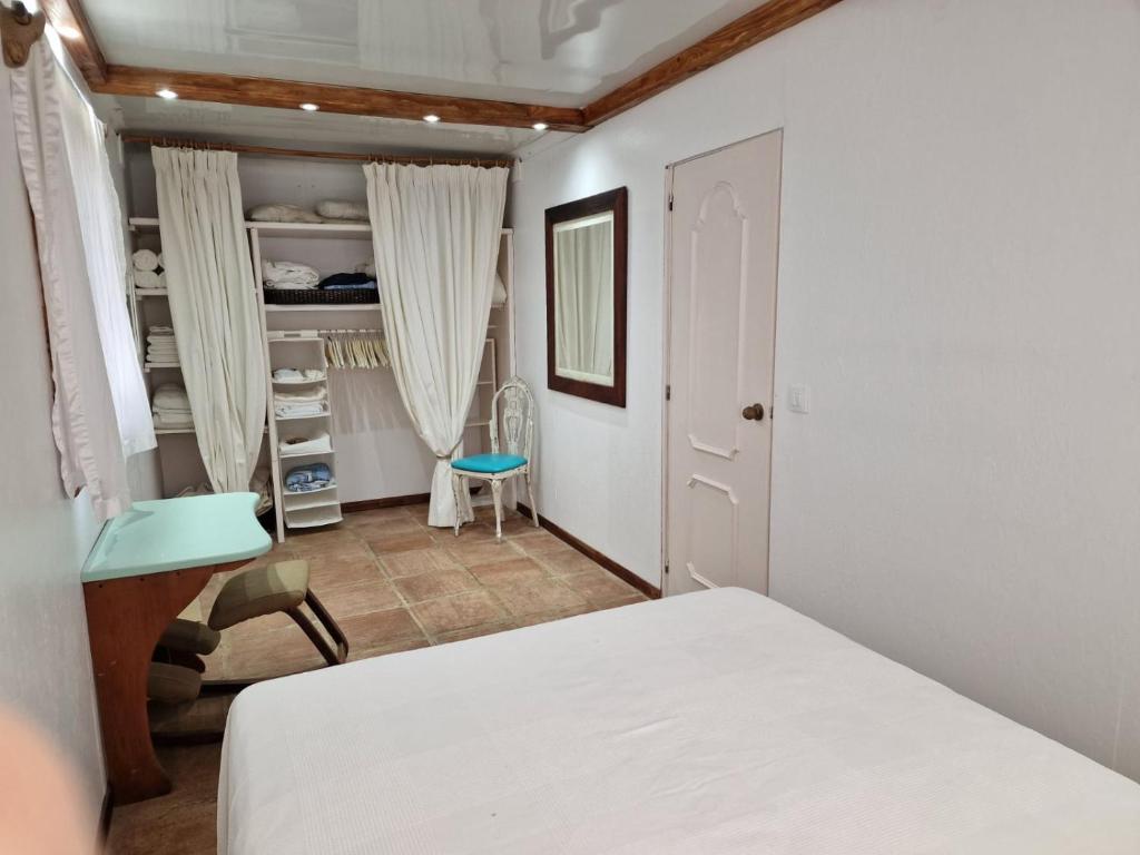 a bedroom with a white bed and a chair at Bolonia Beach Campus in Tarifa