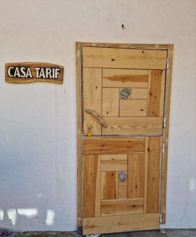 a wooden door with a sign on a wall at Bolonia Beach Campus in Tarifa