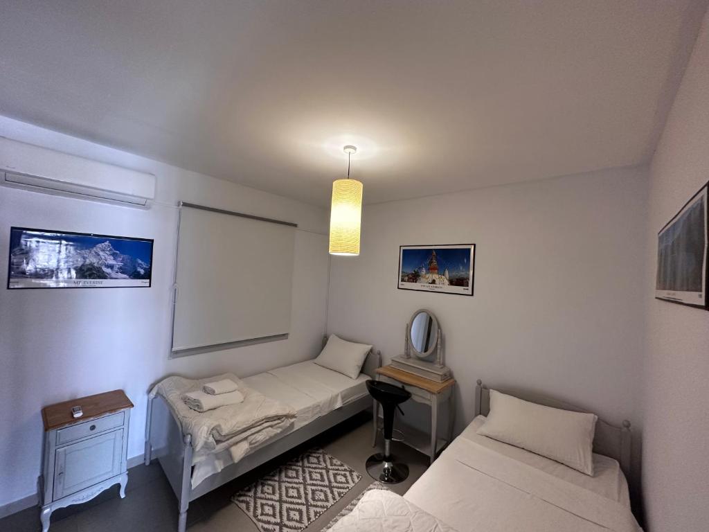 Habitación pequeña con 2 camas y ventana en Seaside Apartments, en Pafos