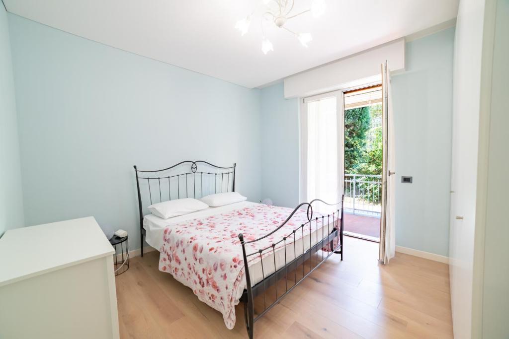 a white bedroom with a bed and a window at Casa Comparin Appartamento Lesa in Lesa