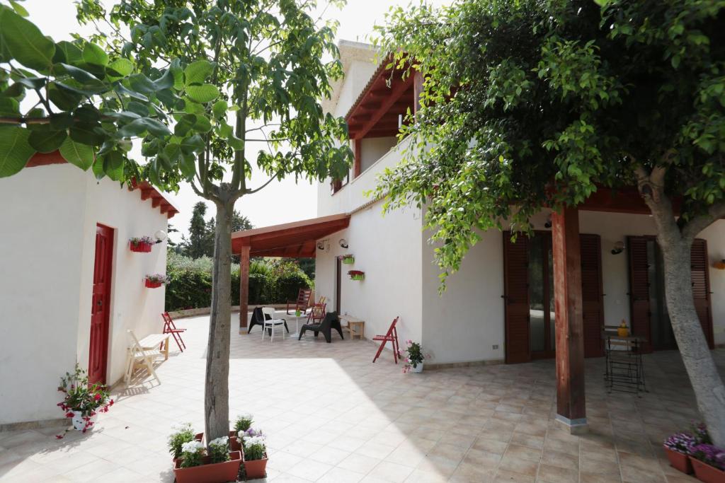 a courtyard of a house with trees and chairs at Villalba Sunrise in Favara