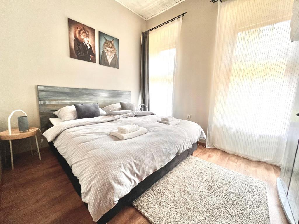 a bedroom with a large bed and a window at Kőház Apartman in Veszprém
