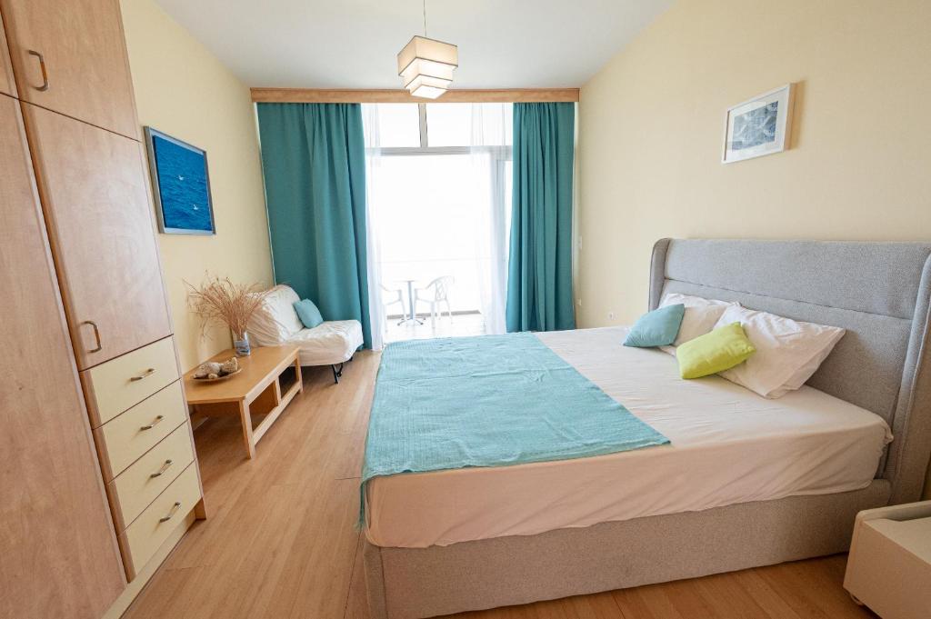 um quarto com uma cama e uma grande janela em Beachfront Studio with Private Path to the Sea em Poros