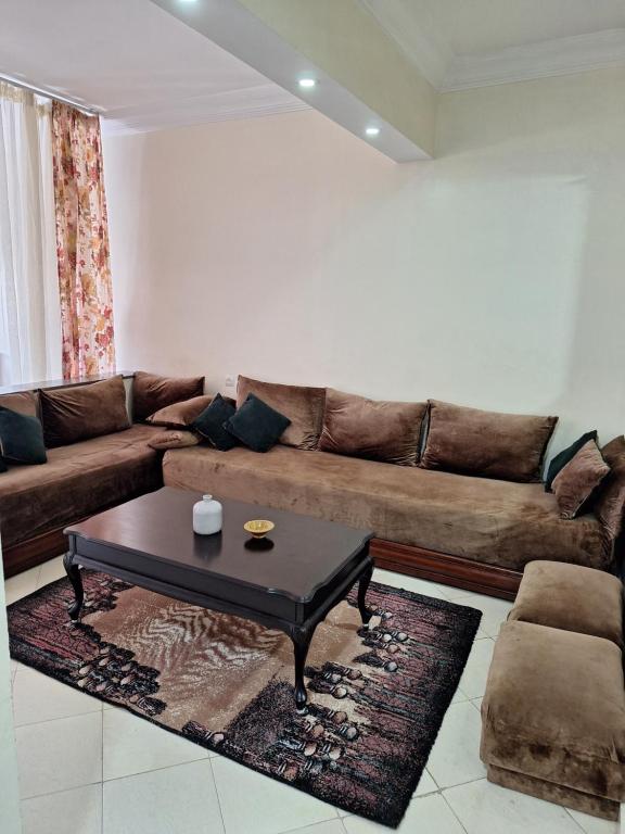 een woonkamer met een bruine bank en een salontafel bij Home Sweet Homes in Rabat