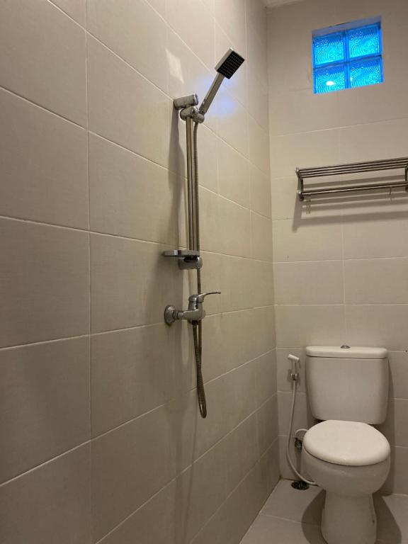 a bathroom with a toilet and a shower at Five Rooms in Canggu