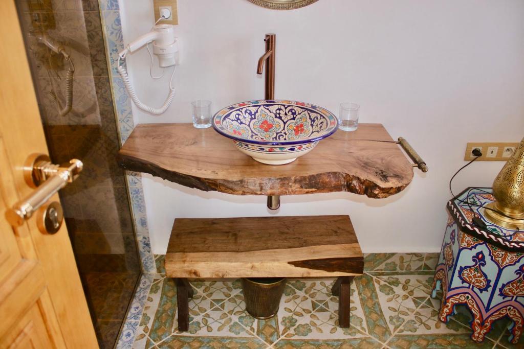 La salle de bains est pourvue d'un lavabo sur une table en bois. dans l'établissement Riad Mellah, à Essaouira