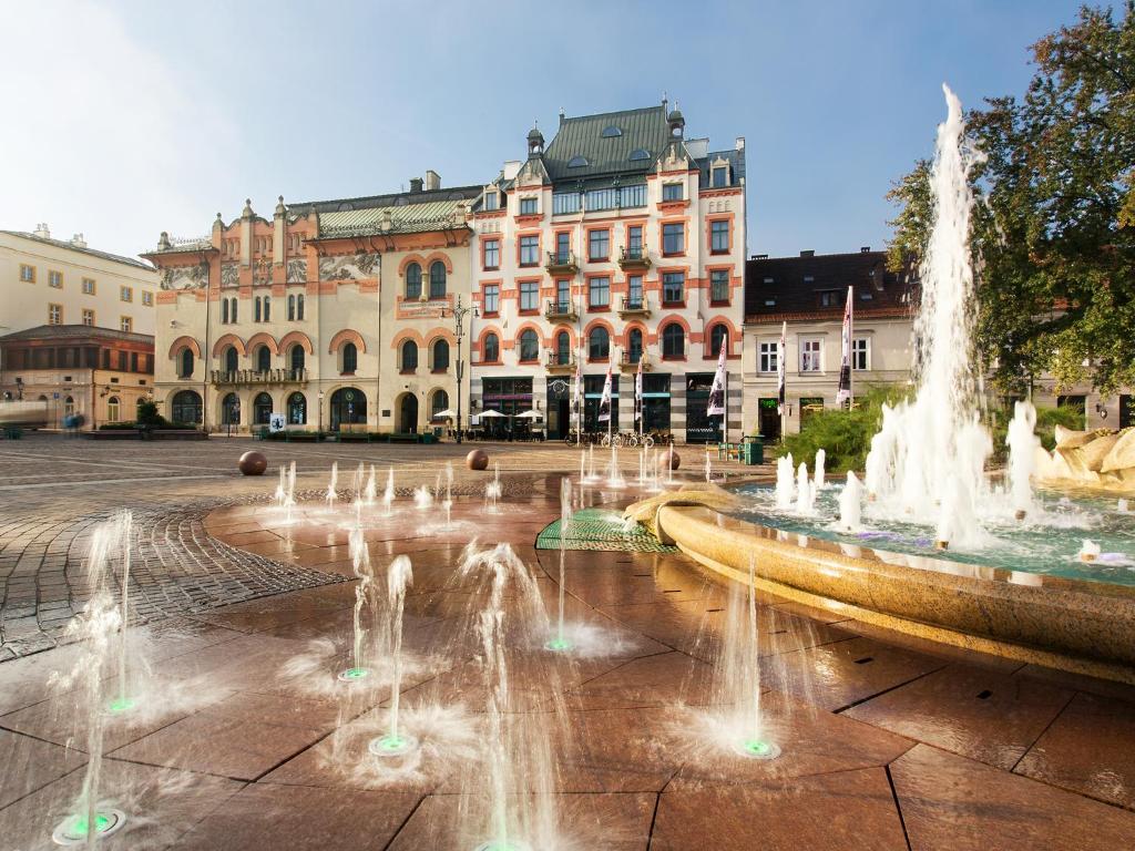 un grupo de fuentes de agua frente a un edificio en Antique Apartments Plac Szczepański, en Cracovia