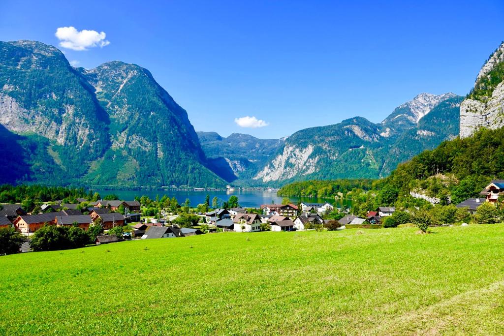 un villaggio con un lago e montagne sullo sfondo di Dormio Resort Obertraun a Obertraun