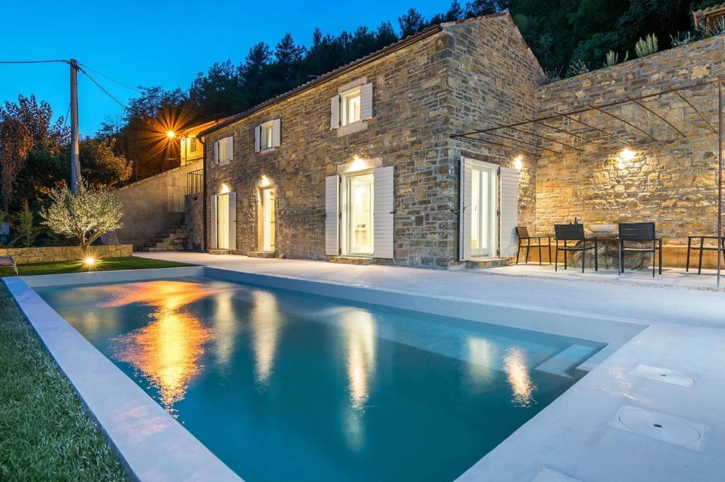 a swimming pool in front of a stone house at Villa Casa Libera in Livade