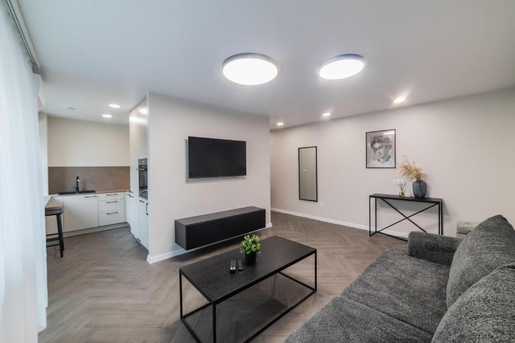 a living room with a couch and a flat screen tv at Frida Apartment in Šiauliai