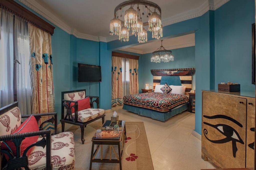 Le Riad Hotel de Charme في القاهرة: غرفة نوم بجدران زرقاء وسرير واريكة