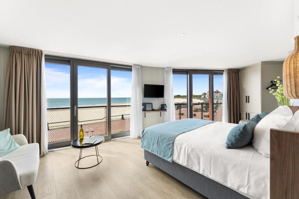 een slaapkamer met een bed en uitzicht op de oceaan bij Suites Boulevard 17 in Vlissingen