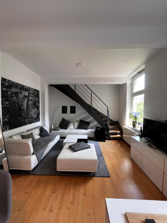 sala de estar amplia con sofá y TV en Traumloft Maisonette, en Düsseldorf