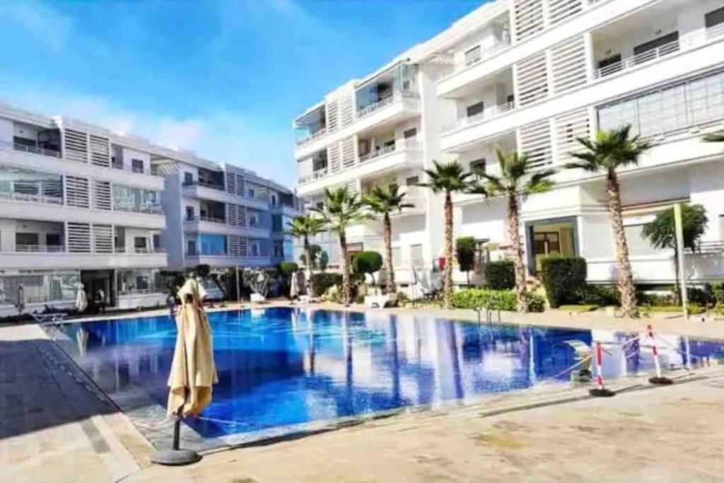 a large swimming pool in front of a building at Cozy Apartment with Pool near Beach in Mohammedia