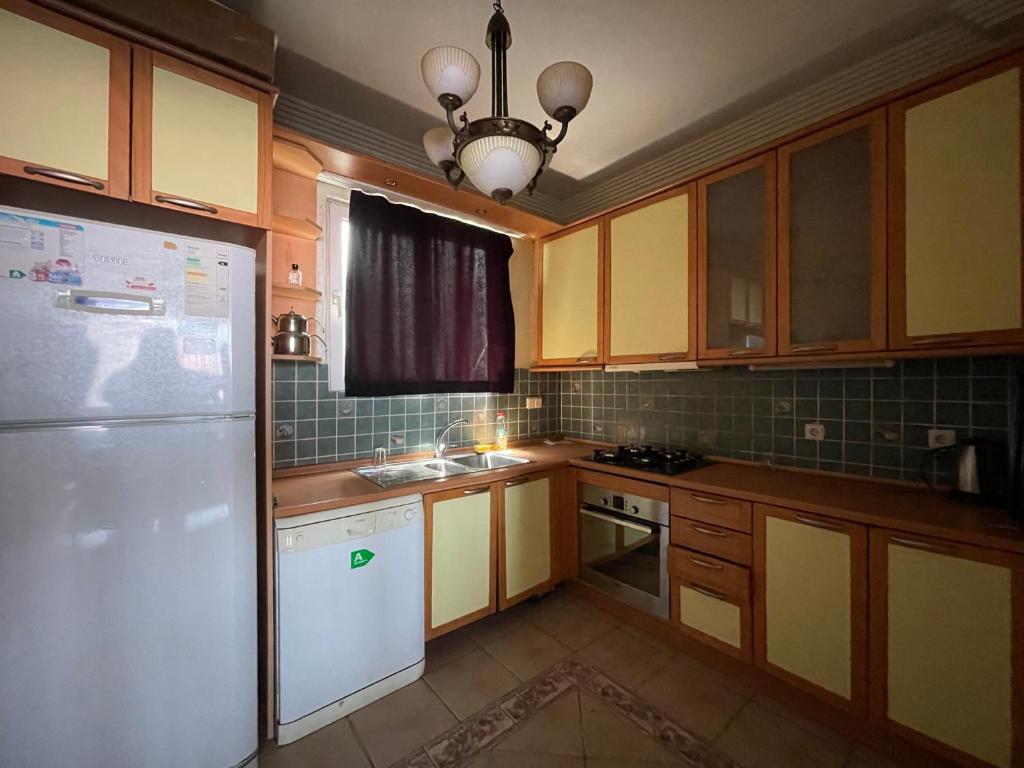 cocina con armarios de madera y nevera blanca en Deniz manzaralı eşyalı kiralık daire 3+1, en Estambul