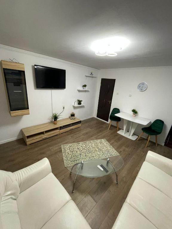 a living room with a white couch and a table at Zya Home Central in Oradea