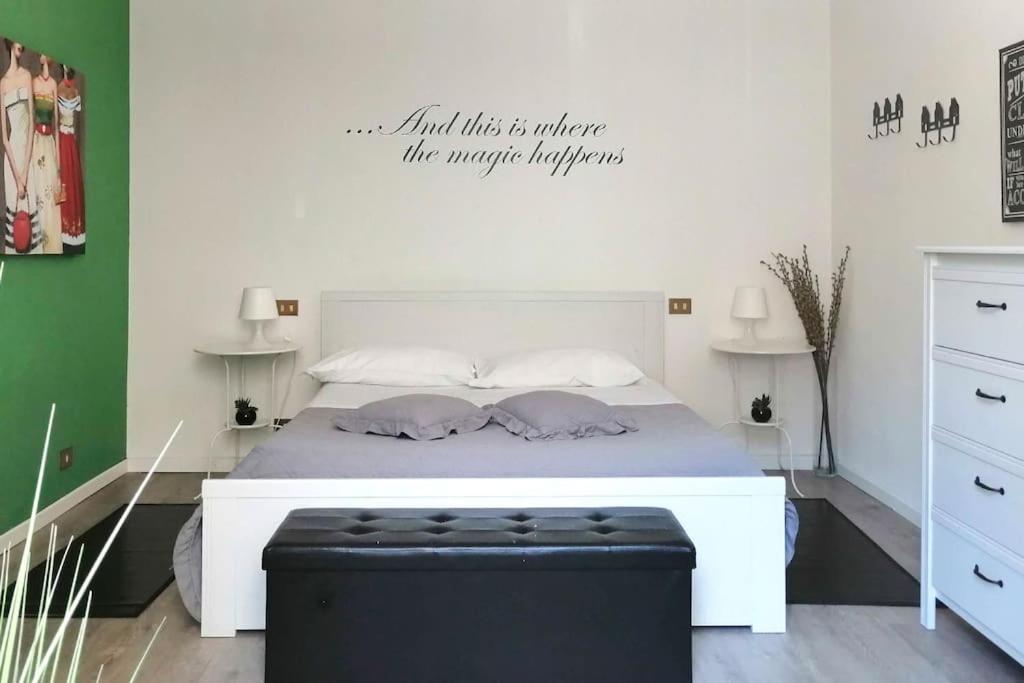a bedroom with a white bed with a sign on the wall at Appartamento Verde in Como